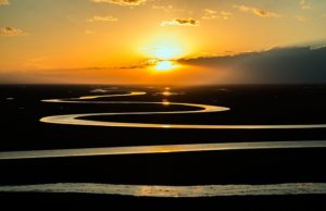 Rüdiger Rauls - Flusslauf im Sonnenuntergang als Symbol für eine neue Welt - Bild: Pixabay.com